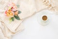 Cozy cream blanket on white bed with espresso and flowers