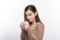 Pretty young woman cupping coffee mug in hands