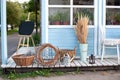 Cozy Decor of terrace of country house. Wicker baskets next to garden tools, watering can and dried spikelets, pampas grass agains Royalty Free Stock Photo