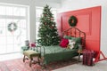 Cozy decorated bedroom for Christmas holidays with a Christmas tree and gifts
