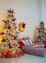 Cozy Decorated white bedroom for holidays with Christmas tree and gifts. Glowing Xmas tree in dark at night. Checkered bedding on