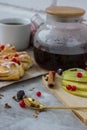 cozy and delicious breacfast with black tea in a transparent kettle, a piece of pie, apple slices and spices Royalty Free Stock Photo