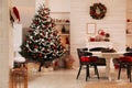 Cozy dining room interior with Christmas tree and festive decor Royalty Free Stock Photo