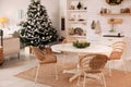 Cozy dining room interior with Christmas tree and festive decor Royalty Free Stock Photo