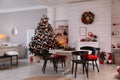 Cozy dining room interior with Christmas tree and festive decor Royalty Free Stock Photo