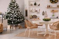 Cozy dining room interior with Christmas tree and festive decor Royalty Free Stock Photo