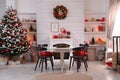 Cozy dining room interior with Christmas tree and festive decor Royalty Free Stock Photo