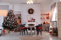 Cozy dining room interior with Christmas tree and festive decor Royalty Free Stock Photo