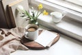 Cozy Easter spring still life. Greeting card mockup scene. Cup of coffee, books, wooden cutting board, milk pitcher and Royalty Free Stock Photo