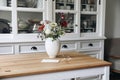 Cozy elegant Swedish Scandinavian style living room, home office. Vintage white cupboard with crockery. Wooden table