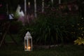 cozy evening garden scene with vintage lantern and candle holder Royalty Free Stock Photo