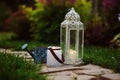 Cozy evening garden scene with vintage lantern and candle holder Royalty Free Stock Photo