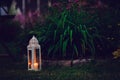 Cozy evening garden scene with vintage lantern and candle holder Royalty Free Stock Photo