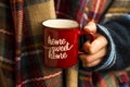 Cozy fall coffee cup, woman hands holding warm rustic autumn coffee cup with cozy scarf