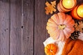 Cozy fall side border with pumpkins, sweaters and candles over a dark wood background