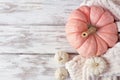 Cozy fall side border on a rustic white wood background with blanket, pink and white pumpkins