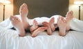 Cozy family lying in bed relaxing sleeping together. Feet and toes of parents and their tired little children sleeping Royalty Free Stock Photo