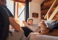 Cozy family tea time. Father and son at the home living room. Boy lying on comfortable sofa and  stroking their beagle dog and Royalty Free Stock Photo