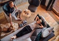 Cozy family tea time. Father and son in the home living room. Men petting their beagle dog and. Boy lying on a comfortable sofa Royalty Free Stock Photo