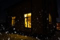 Cozy festive window of the house outside with the warm light of fairy lights garlands inside - celebrate Christmas and New Year in Royalty Free Stock Photo