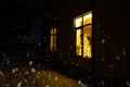 Cozy festive window of the house outside with the warm light of fairy lights garlands inside - celebrate Christmas and New Year in Royalty Free Stock Photo