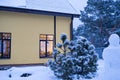 Cozy festive window of the house outside with the warm light of fairy lights garlands inside - celebrate Christmas and New Year in Royalty Free Stock Photo