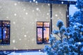 Cozy festive window of the house outside with the warm light of fairy lights garlands inside - celebrate Christmas and New Year in Royalty Free Stock Photo