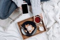 Cozy flatlay of bed with wooden tray with vegan apple pie, ice cream and black tea Royalty Free Stock Photo