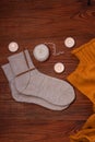 Cozy flatlay. Winter concept. Flat lay of knitted sweater, candles, needles and yarn on wooden background. Warm weekend