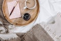 Cozy flatlay with wooden tray, cup of coffee or cocoa, candle, notebooks