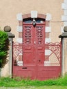 Cozy front door entrance in red colour of residential building in French village Vintage architecture Royalty Free Stock Photo