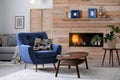 Cozy furnished apartment with niche in wooden wall and armchair. Royalty Free Stock Photo