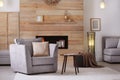 Cozy furnished apartment with niche in wooden wall and armchair Royalty Free Stock Photo