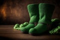 Cozy Green Knitted Boots and Blanket on Wooden Floor. Green leprechaun shoes for St. Patrick\'s Day