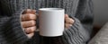 The cozy hands holding a blank white mug in a soft sweater..AI generated image Royalty Free Stock Photo