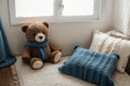 Cozy holidays at home. Cute little lying under blue knitted blanket with teddy bear on floor at window reading book. Winter season