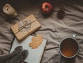 Cozy home in autumn. Notepad with cats paws, gift and cup of hot tea. Top view.