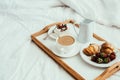 Cozy home breakfast in bed in white bedroom interior Royalty Free Stock Photo