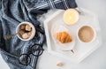 Cozy home breakfast, warm blanket, coffee and croissant on white