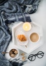 Cozy home breakfast, warm blanket, coffee and croissant on white