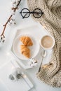 Cozy home breakfast, warm blanket, coffee and croissant on white
