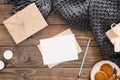 Cozy home desk, hygge, autumn fall concept. Blank paper card mockup, craft envelope, cookies, candles, women fashion scarf, gift