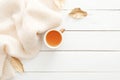 Cozy home desk table with knitted plaid, tea cup, fall leaves on wooden white background. Top view, flat lay, copy space. Autumn Royalty Free Stock Photo