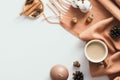 Cozy home desk table with scarf, coffee cup, cotton, pine cones, cinnamon sticks on white. Flat lay, top view, copy space Royalty Free Stock Photo