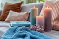 Cozy Home Interior with Lit Candles, Comfortable Cushions, Books, and Knitted Blanket on Sofa Setting