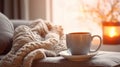 Cozy home setting with a hot cup of tea on a couch, soft knitted blanket, and warm candlelight in a serene atmosphere