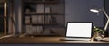 A cozy home workspace features a white-screen laptop mockup and decor on a hardwood desk Royalty Free Stock Photo