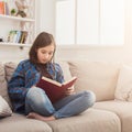 Cozy home. Young thoughtful girl with book Royalty Free Stock Photo