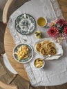 Cozy homemade breakfast - pancakes with apple sauce on vintage dishes, a bouquet of asters, green tea on a wooden table, top view