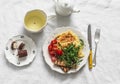 Cozy homemade brunch - omelette with arugula, cherry tomatoes, whole grain toast, green tea, chocolate dessert on a light